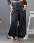 Person wearing dark blue wide-leg pants with a gray background