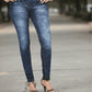 Person wearing blue jeans standing on a street.