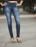 Person wearing blue jeans standing on a street.
