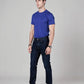 Man wearing a blue t-shirt and dark jeans on a gray background