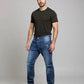 Man wearing a black t-shirt and blue jeans on a gray background