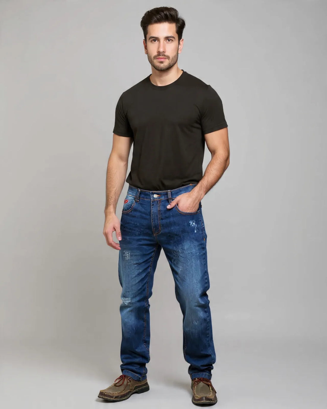 Man wearing a black t-shirt and blue jeans on a gray background