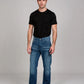Man wearing a black t-shirt and blue jeans on a gray background