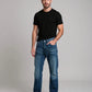 Man wearing a black t-shirt and blue jeans against a gray background