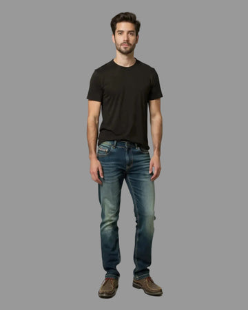 Man wearing a black t-shirt and blue jeans against a gray background