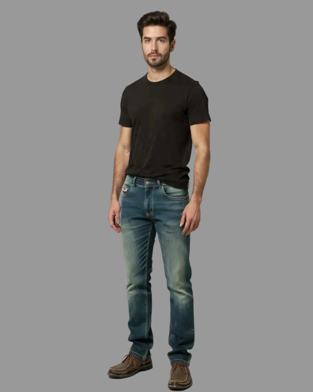 Man wearing a black t-shirt and blue jeans against a gray background