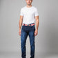 Man wearing a white t-shirt, blue jeans, and black shoes on a gray background