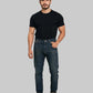 Man wearing a black t-shirt and blue jeans on a white background