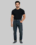 Man wearing a black t-shirt and blue jeans on a white background