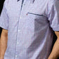 Man wearing a short-sleeve checkered shirt against a black background