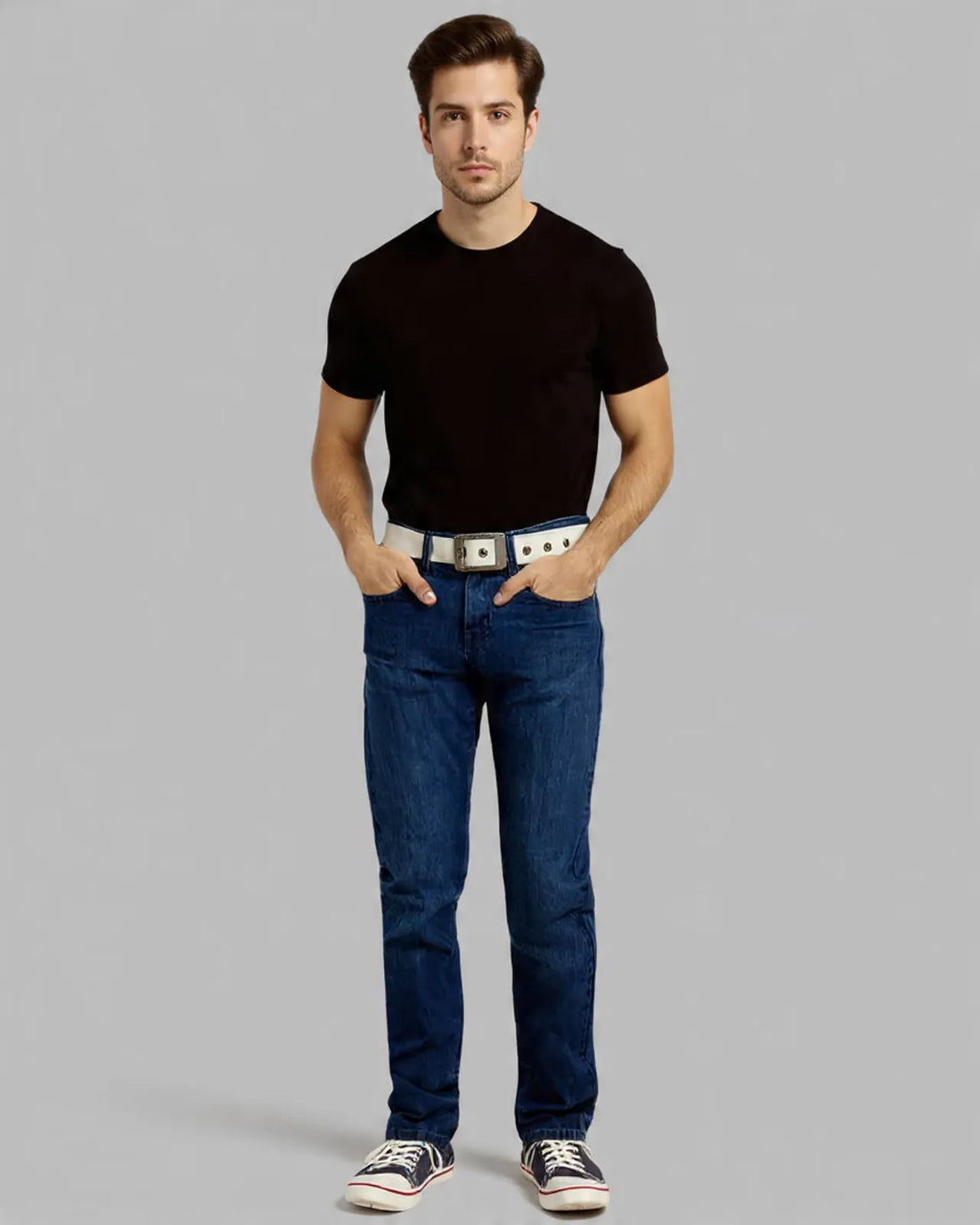 Man wearing a black t-shirt, blue jeans, and white sneakers on a gray background