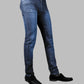 Blue jeans worn by a person on a gray background