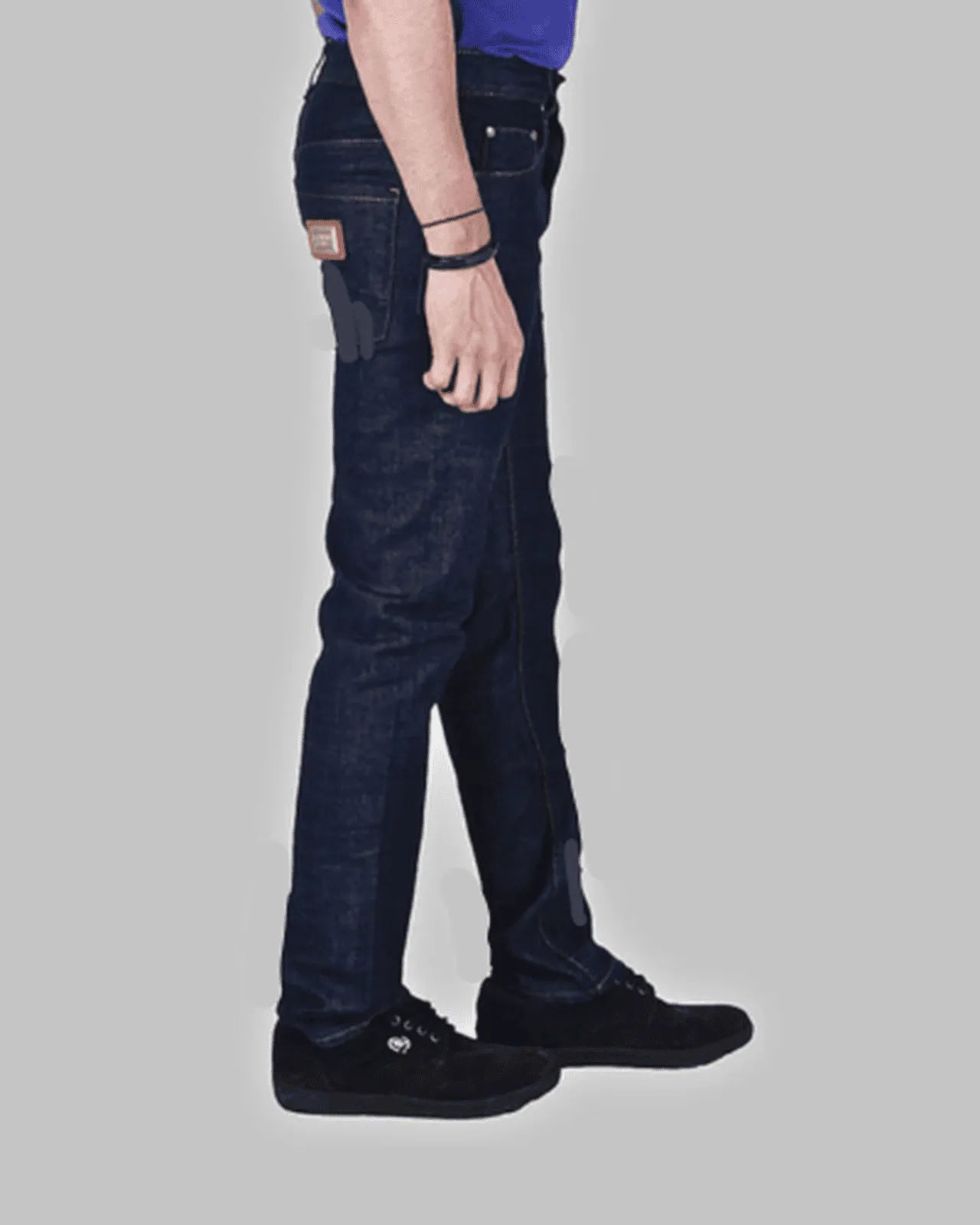 Person wearing dark blue jeans on a gray background