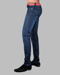 Blue jeans worn by a person on a gray background