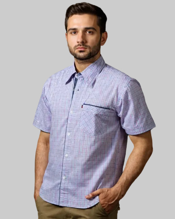 Man wearing a short-sleeve checkered shirt against a black background