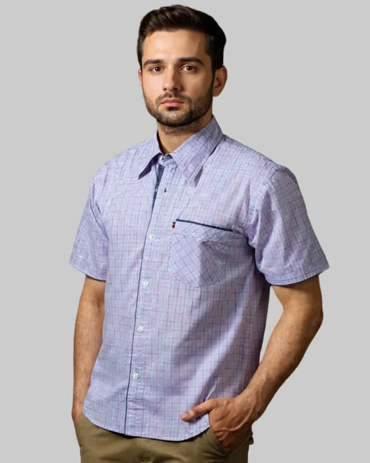 Man wearing a short-sleeve checkered shirt against a black background