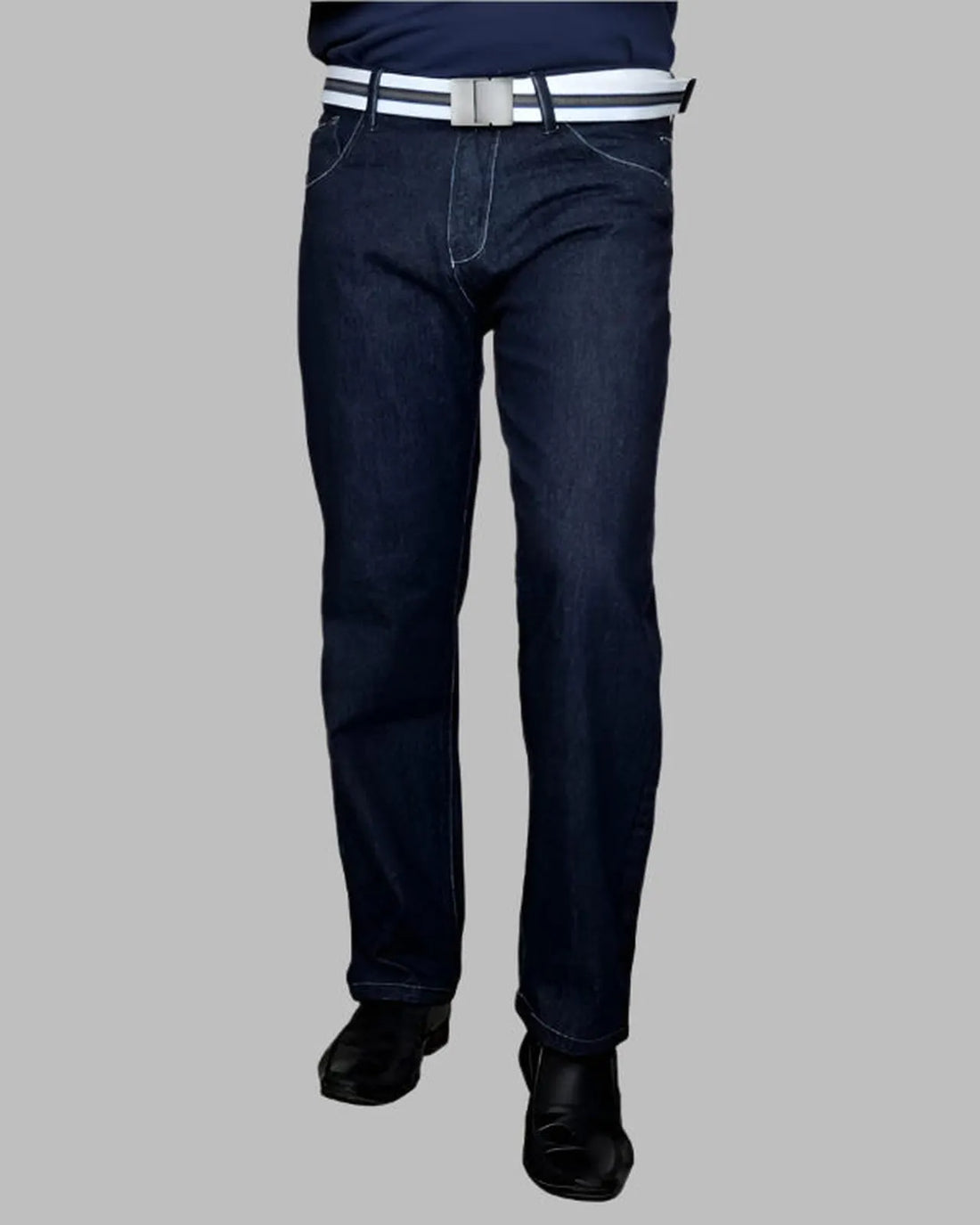 Dark blue jeans worn by a person on a gray background