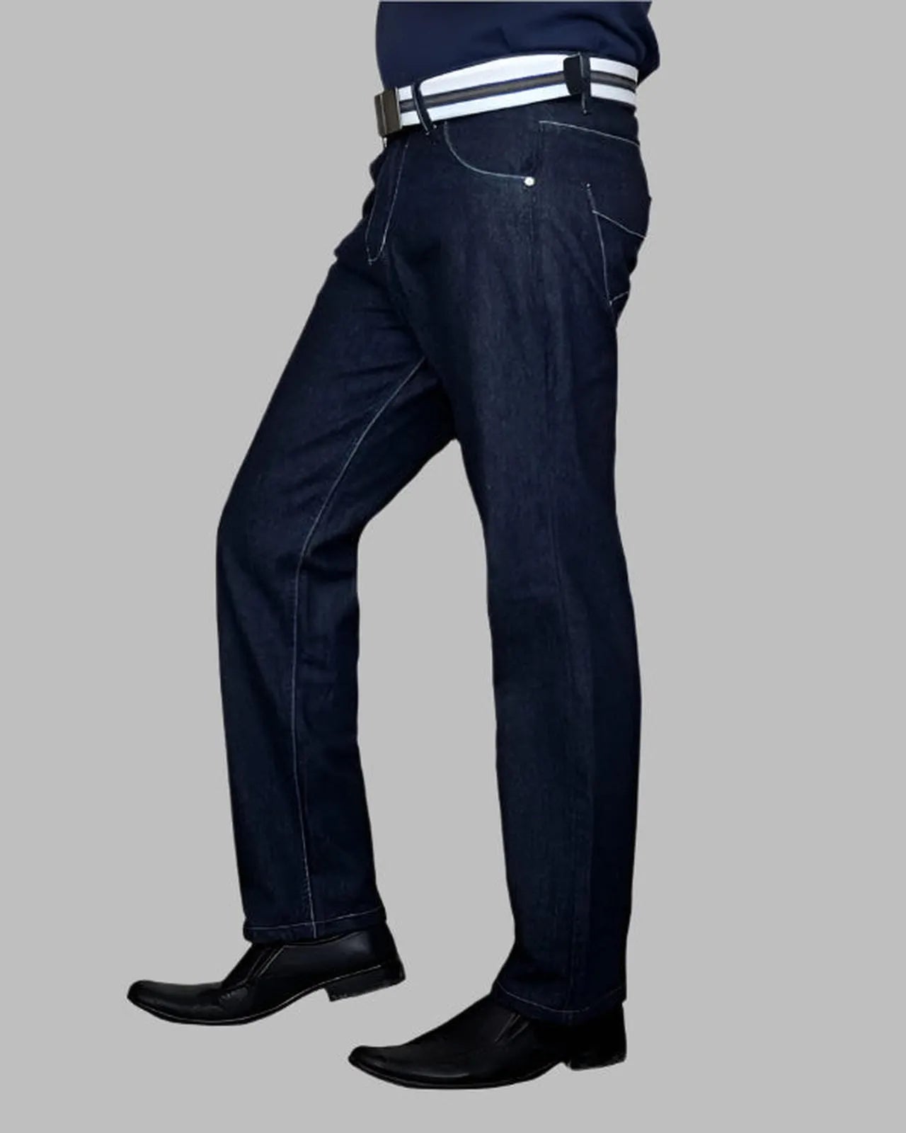 Dark blue jeans worn by a person on a gray background