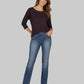 Woman wearing a dark purple top and blue jeans on a gray background