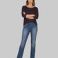 Woman wearing a dark purple sweater and blue jeans on a white background