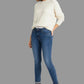 Woman wearing a white sweater and blue jeans on a white background