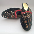 Pair of embroidered slippers with floral patterns on a light gray background