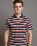 Man wearing a striped polo shirt against a gray background