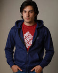 Man wearing a blue hoodie over a red shirt with white text on a plain background