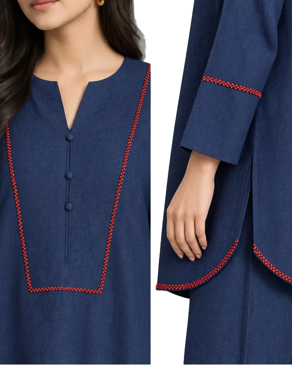 A woman modeling a navy blue two-piece kurta set with red contrast stitching details, standing against a neutral gray studio background.