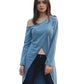 Woman wearing a blue off-shoulder top and dark jeans outdoors.