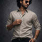 Man wearing a light Olive shirt and sunglasses against a dark background
