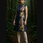 Woman wearing a denim sleeveless top with gold embroidery in a forest setting