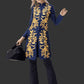 Woman wearing a blue embroidered coat with gold patterns on a black background