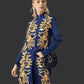 Woman wearing a denim coat with gold embroidery on a dark background