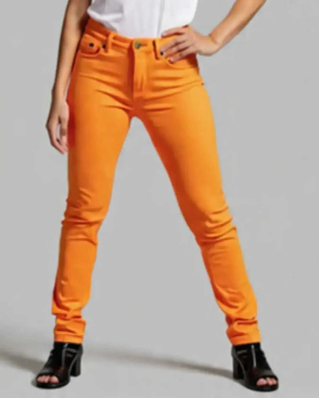 Person wearing bright orange pants on a plain background