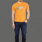 Man wearing an orange t-shirt with a logo and blue jeans on a gray background