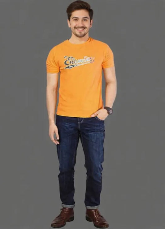 Man wearing an orange t-shirt with a logo and blue jeans on a gray background