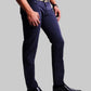 Person wearing navy blue pants and black shoes on a light gray background