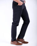 Person wearing black pants and brown shoes on a white background