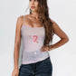 Woman wearing a light purple tank top with a pink ribbon design on a white background