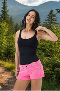 Woman wearing a black tank top and pink shorts on a white background
