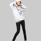 Person wearing a white hoodie with text and black pants on a gray background