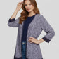 Woman wearing a patterned cardigan over a plain top and jeans on a light gray background