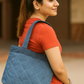 Woman carrying a blue quilted handbag on a blurred background