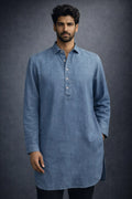 Man wearing a blue long-sleeve shirt against a dark background