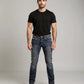 Man wearing a black t-shirt and blue jeans on a gray background