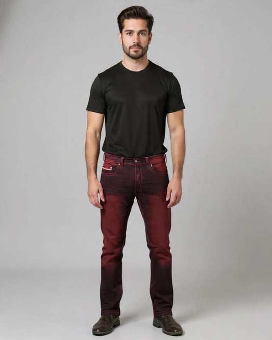 Man wearing a black t-shirt and maroon jeans against a gray background