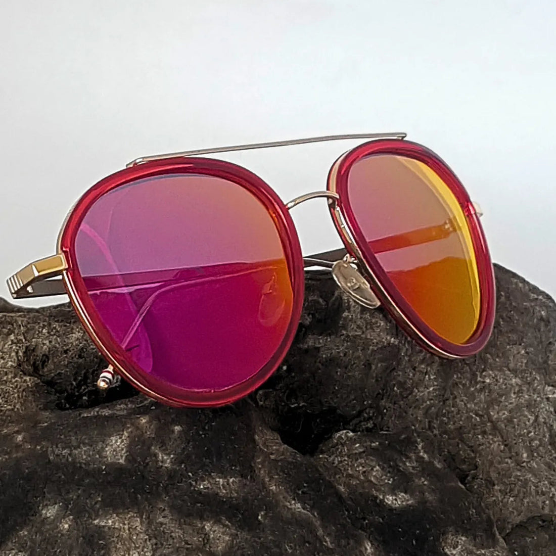 Sunglasses with Red reflective lenses on a textured surface