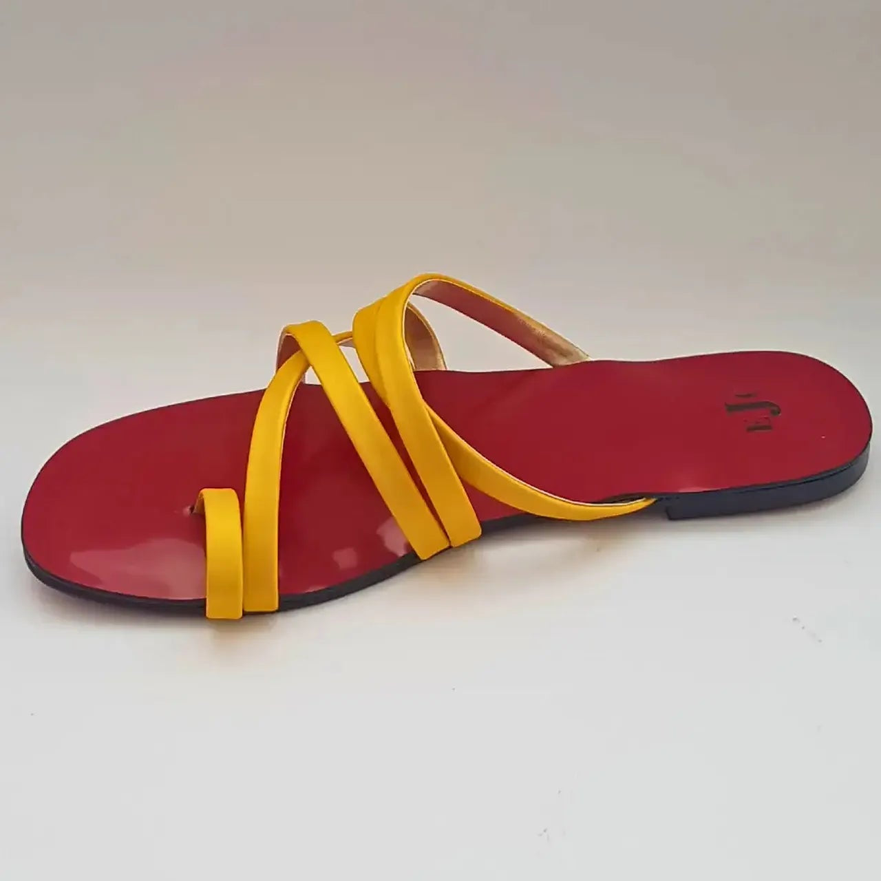 Red sandal with yellow straps on a white background