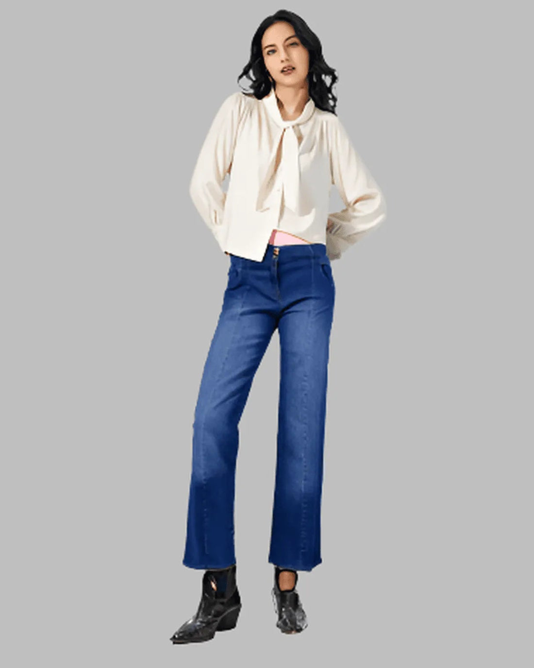 Woman wearing a white blouse and blue jeans on a gray background